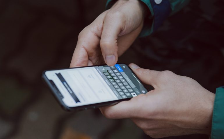 iPhoneを手に持っている男性の手