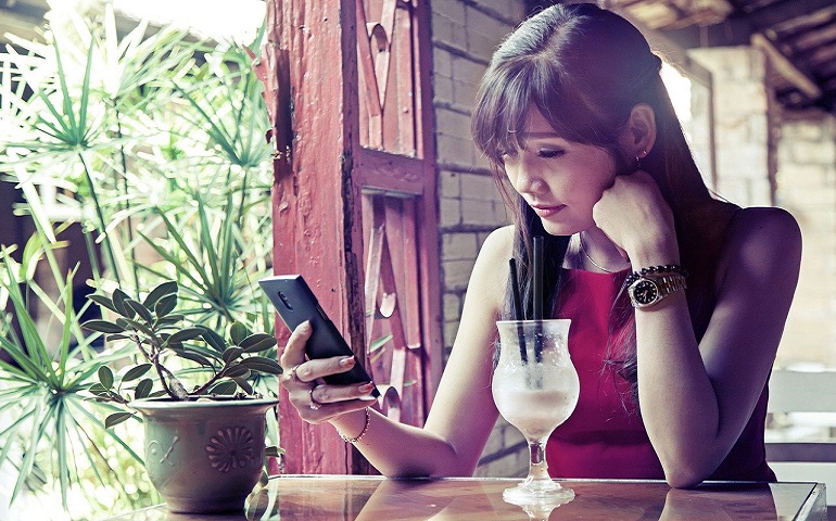 カフェでスマホを眺める女性