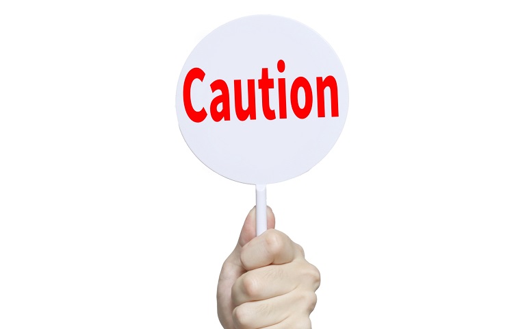 caution札を持つ手元