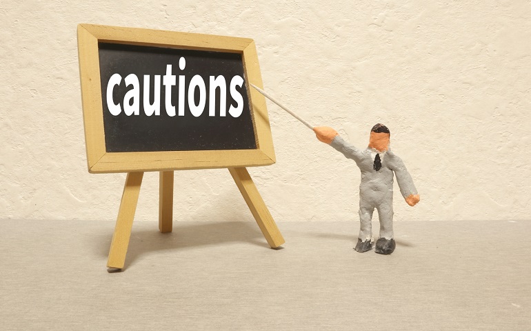 cautionの文字を指すフィギュア